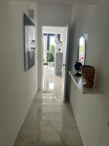 a hallway with a mirror and some vases on a shelf at Blumoon boutique in Andria