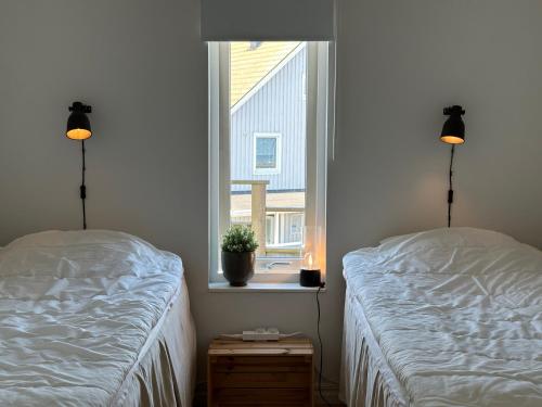 2 Betten in einem Zimmer mit Fenster in der Unterkunft Kustidyll med havsutsikt in Hyppeln