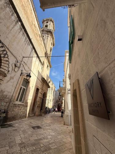 an alley with a sign on the side of a building at Victory Suite in Monopoli