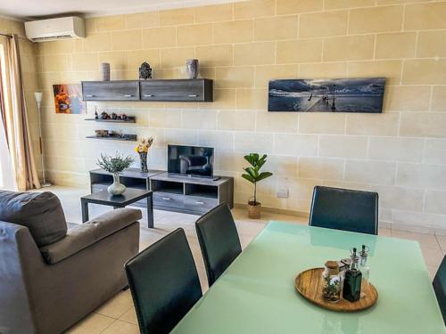 a living room with a table and a couch at Iz-Ziffa Penthouse - Hosted by Encanto Gozo in Qala