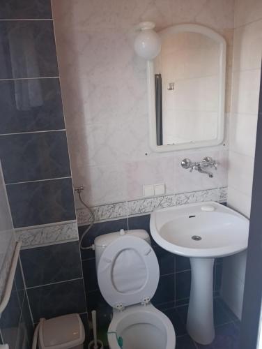 a bathroom with a sink and a toilet and a mirror at U Jaśka in Darłówko