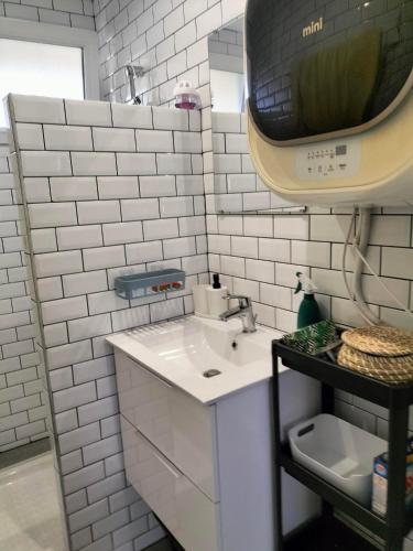 une salle de bain blanche avec un lavabo et un miroir dans l'établissement appartement en plein coeur de ville, à Lannion