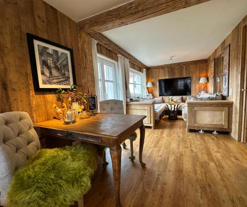 a living room with a table and a couch at Weißt Du noch - Gästehäuser & Suiten in Kühlungsborn
