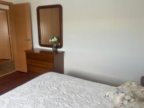 a bedroom with a bed and a dresser with a mirror at Casa Vista Alegre en Oia in Oia