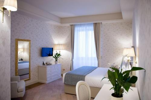a bedroom with a bed and a mirror at San Gemini Palace in San Gemini