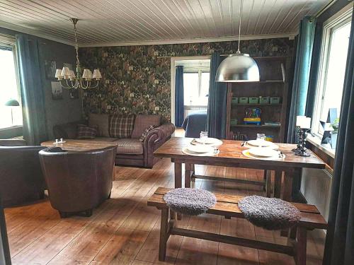a living room with a table and a couch at Peaceful space in the midst of forest in Näsum