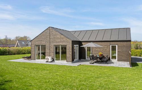 a small wooden house with a table and an umbrella at Cozy Home In Frørup With Jacuzzi in Frørup