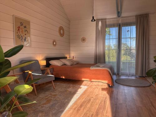 a bedroom with a bed and a large window at Dla Pary - Sauna, Joga, Masaż, Jezioro in Mikołajki