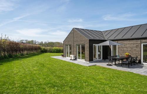a barn conversion with a patio and grass yard at Cozy Home In Frørup With Jacuzzi in Frørup