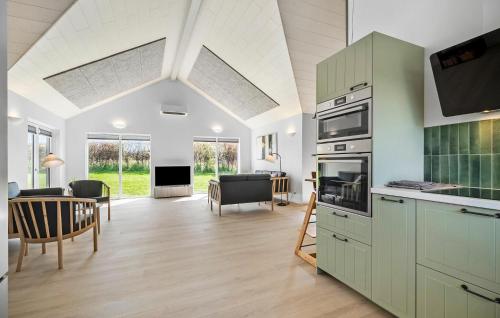 a kitchen with green cabinets and a living room at Cozy Home In Frørup With Jacuzzi in Frørup