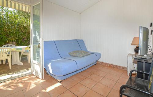 - un canapé bleu dans l'angle de la chambre dans l'établissement Villa Plage À Pieds, à Moriani-Plage