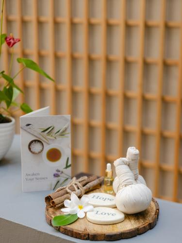 a table with a book and a towel and a bottle of perfume at The Westin Goa in Vagator