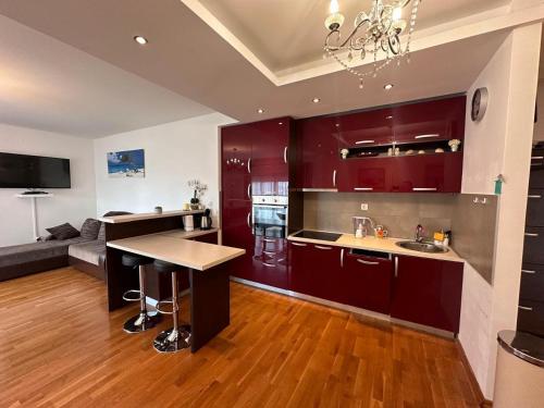 ラファイロヴィチにあるApartments EVGの赤いキャビネットとテーブル付きのキッチンが備わります。