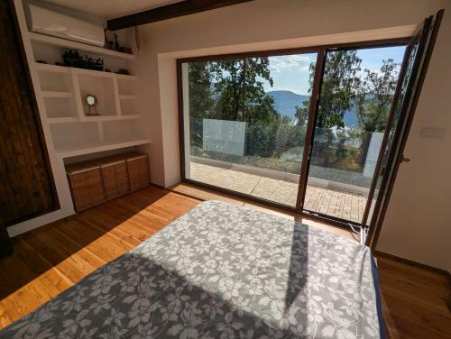 a room with a large window and a bed in front at Modernistyczna willa poety i aktorki, z widokiem na jezioro i góry oraz prywatnym basenem, sauną, kominkiem, lasem i ogrodem in Rożnów