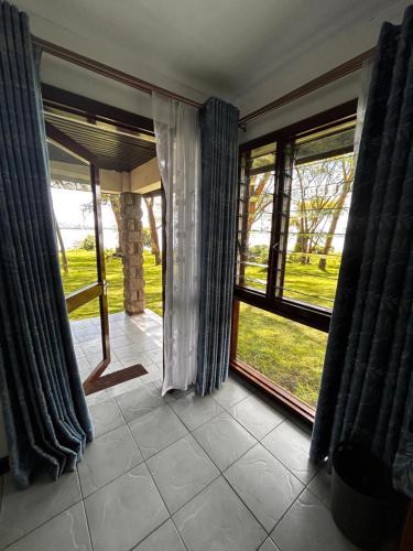 a room with windows and a view of a yard at Elsamere Lodge Naivasha in Naivasha