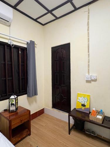 a room with a room with a door and a table at Manotemple Guest House in Luang Prabang
