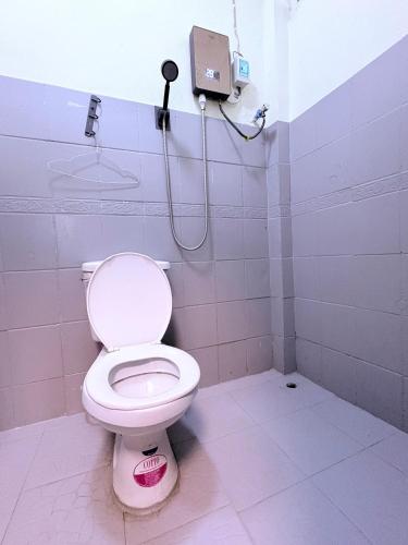 a bathroom with a white toilet in a stall at Manotemple Guest House in Luang Prabang