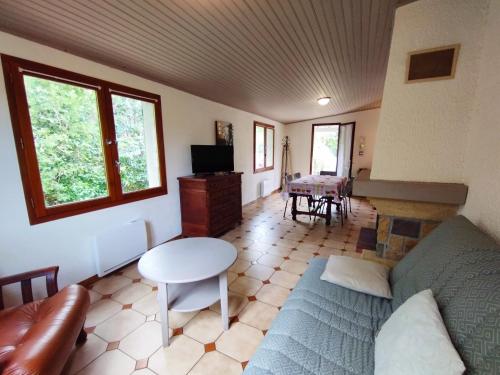 a living room with a couch and a table at Le Cabrials in Le Poujol-sur-Orb