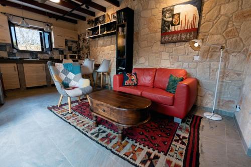 a living room with a red couch and a table at Traditional Stone House - Where Tradition Meets Comfort in Mesa Chorio