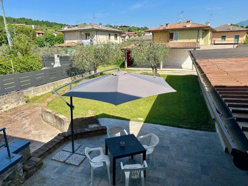 a patio with a table and chairs and an umbrella at B&B LA CORTE in Puegnano del Garda