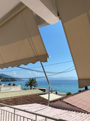 a view of the ocean from a beach with an umbrella at Phebiata in Ýpsos