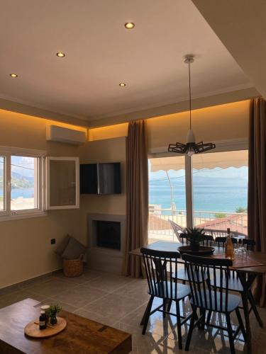 a living room with a table and chairs and a view of the ocean at Phebiata in Ýpsos