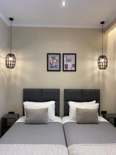 two beds in a bedroom with two pendant lights at Phebiata in Ýpsos