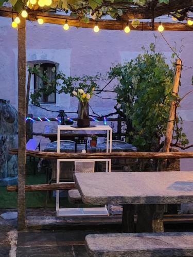 a table with a bench and a vase of flowers at B&B Osteria Morganti in Someo