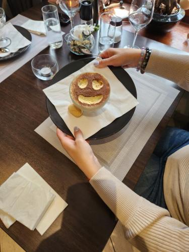 a person sitting at a table with a plate with a cake at B&B Osteria Morganti in Someo