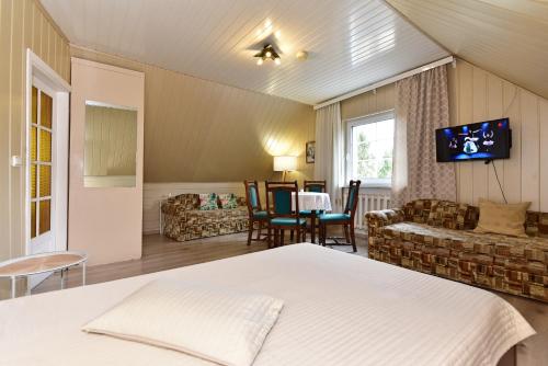 a bedroom with a bed and a living room at Augutės Zurlienės apartamentai in Trakai