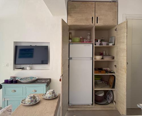 a kitchen with a white refrigerator and a table at Chalet Tango in Contrada Sauci Grande