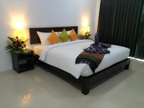 شقة ذا سيشور كمالا المخدومة في شاطئ كامالا: غرفة نوم مع سرير أبيض كبير مع وسائد ملونة