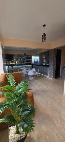 ein Wohnzimmer mit einer Couch und einer Pflanze in der Unterkunft A Oasis Taveta in Taveta