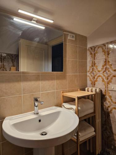 a bathroom with a white sink and a mirror at La dolce vita Giove apartment in Giove