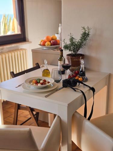 a white table with a plate of food and glasses of wine at La dolce vita Giove apartment in Giove