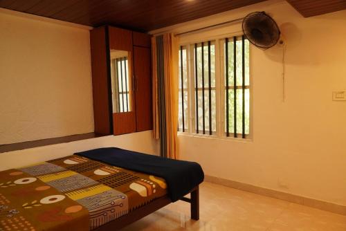 a bedroom with a bed and a window at Wilderstay Resort in Meppādi