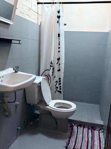 a bathroom with a toilet and a sink and a shower at Manotemple Guest House in Luang Prabang