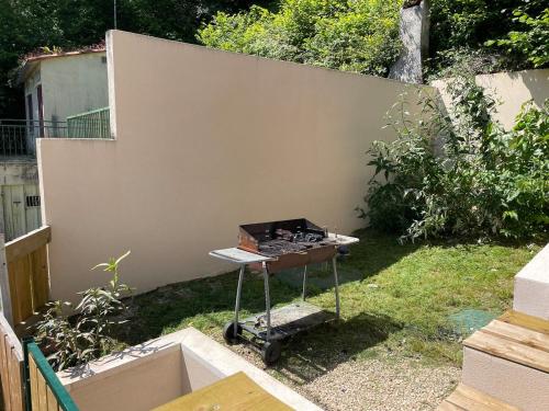 a grill in a yard next to a wall at La Capiniella in La Chapelle-Moulière