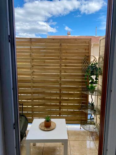 un balcon avec une clôture d'intimité en bois et une table dans l'établissement Studio tout confort proche Gare RER D, à Goussainville