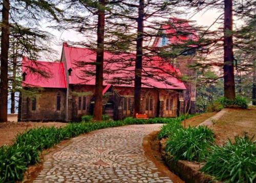 a house with a red roof and a walkway at Feel at Home Tranquil trails home stay naddi in Dharamshala