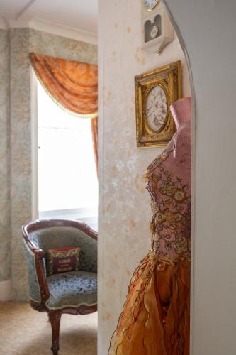 a mirror in a room with a chair and a clock at Enchanted Manor in Niton