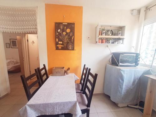 a dining room with a table and a tv at תכלת המדבר in Mitzpe Ramon