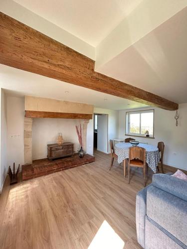 un salon avec une table et une cheminée dans l'établissement La petite maison, à Gouffern en Auge