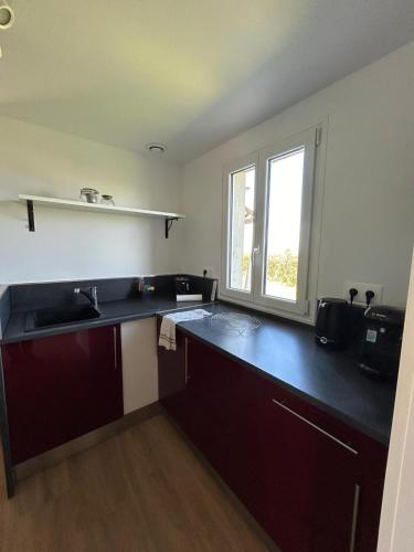 une cuisine avec un évier et une fenêtre dans l'établissement La petite maison, à Gouffern en Auge