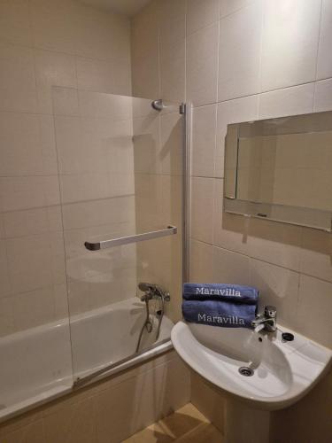 a bathroom with a sink and a bath tub with a mirror at Penthouse Las Terrazas de la Torre in Roldán
