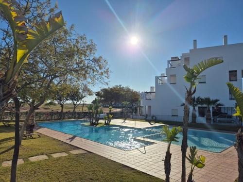 una piscina con alberi di fronte a un edificio di Penthouse Las Terrazas de la Torre a Roldán