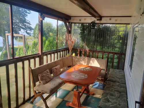 a screened in porch with a table and a bench at Antera Peaceful Escape in Gorowychy Małe