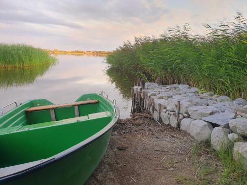 a green boat sitting next to a stone wall at Antera Peaceful Escape in Gorowychy Małe