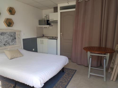 une petite chambre avec un lit et une table dans l'établissement studio centre ville Agen, à Agen