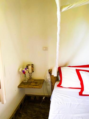 a bedroom with a red and white bed and a table at Villa vii in Malindi
